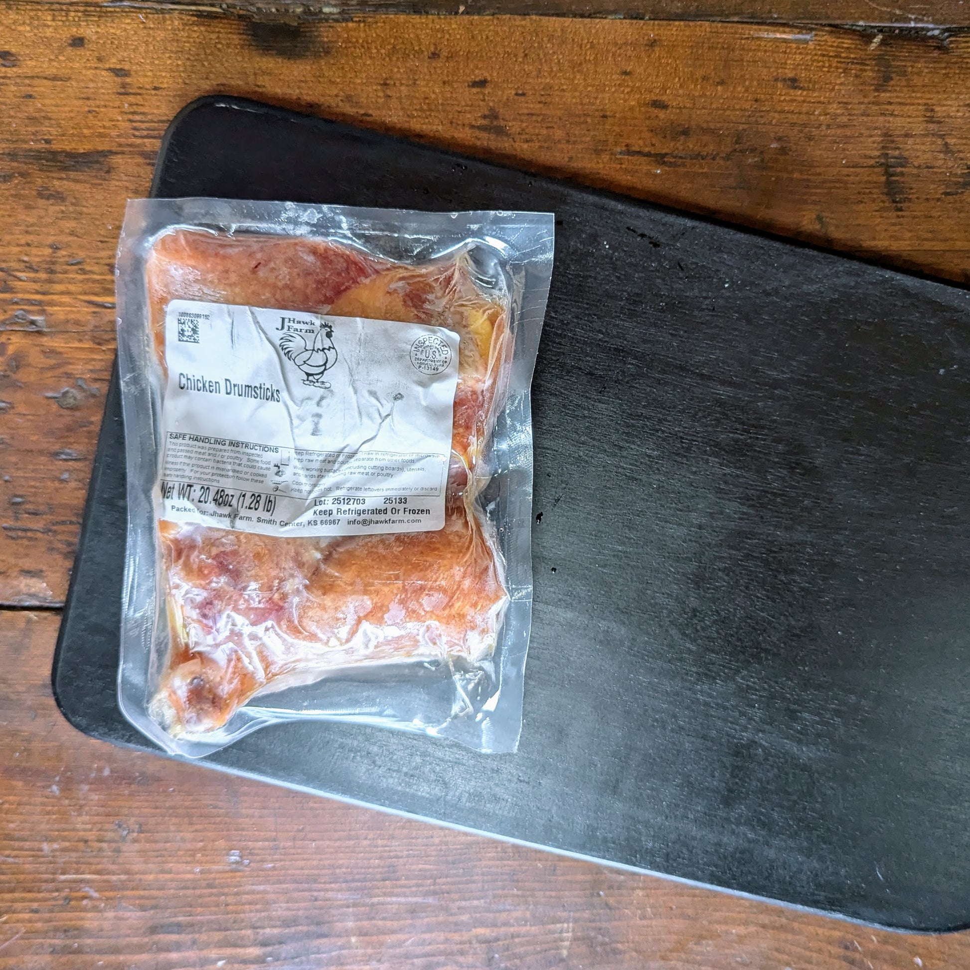 Packaged chicken drumsticks on a wooden surface