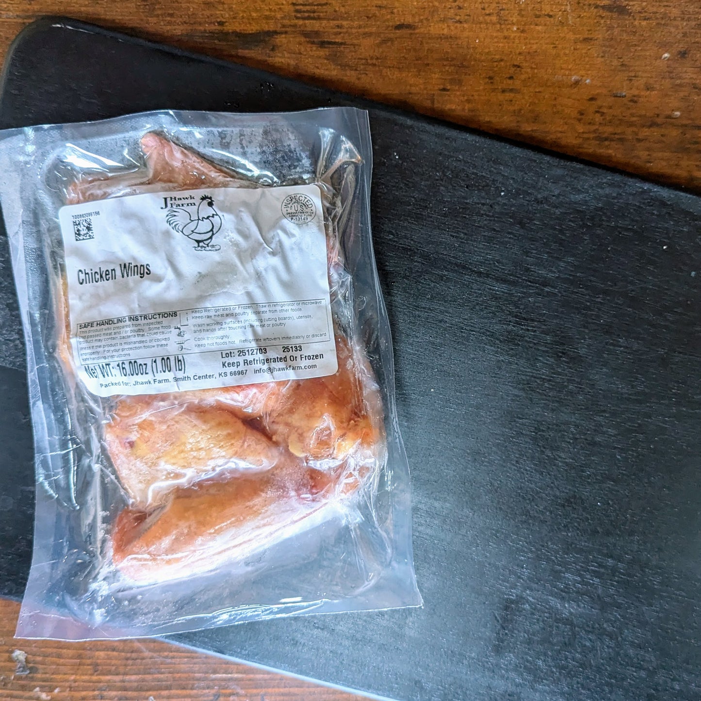 Package of chicken wings on a wooden surface