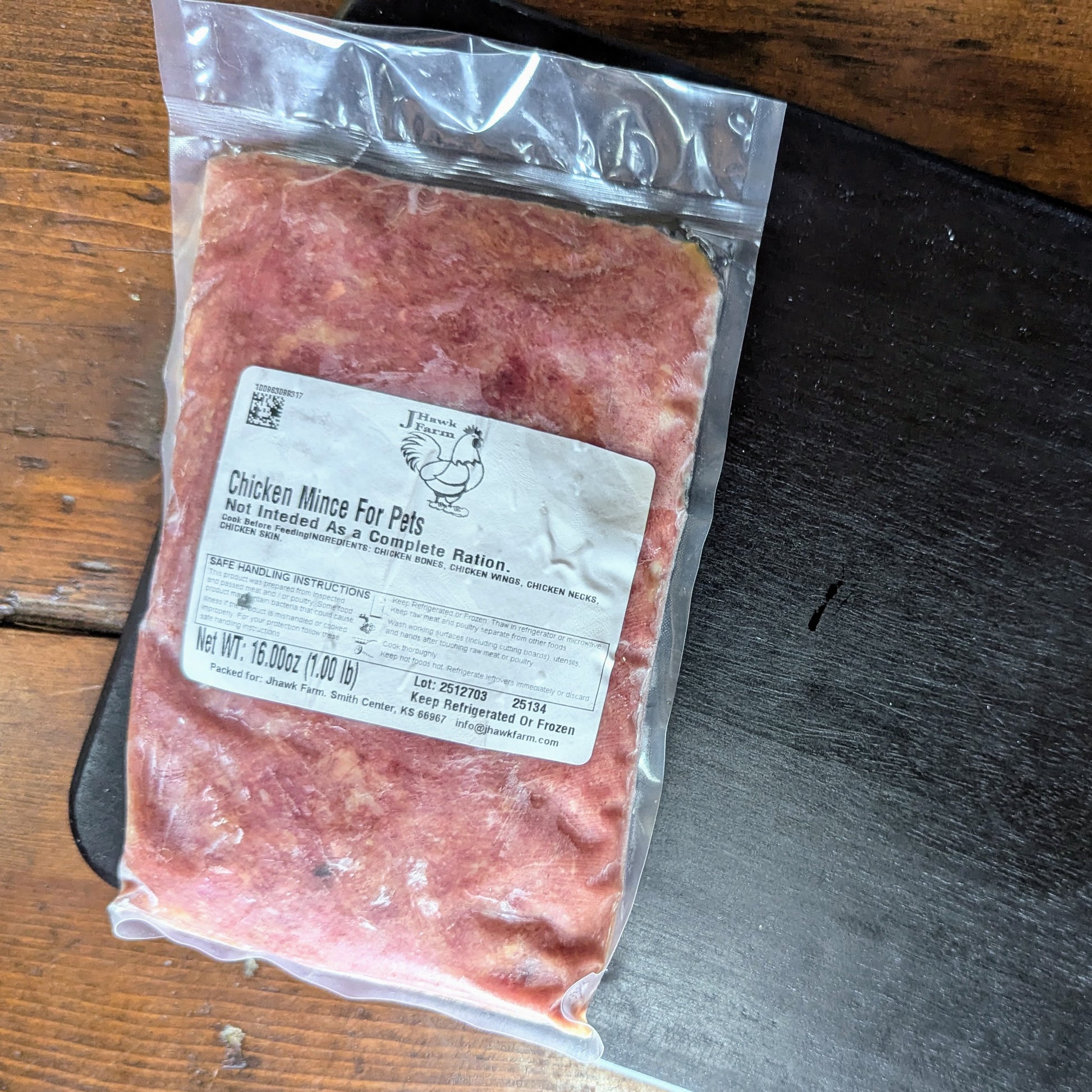 Package of chicken mince for pets on a wooden surface