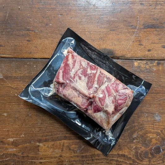 Raw beef on a black plastic tray on a wooden surface